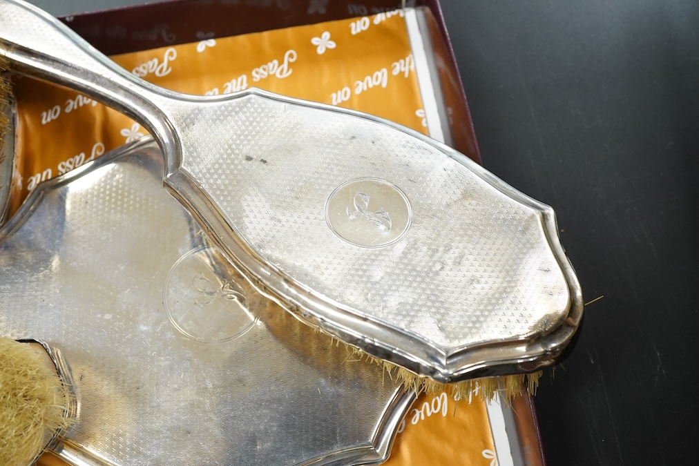 A George V silver engine turned four piece dressing table set and a pair of clothes brushes hand mirror length 19.3cm.